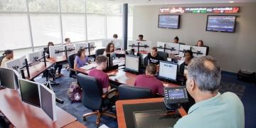 Professor in classroom with business students at computers