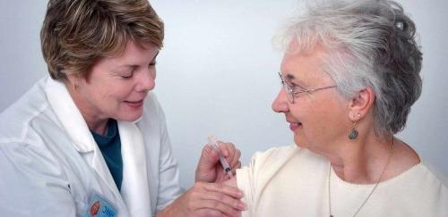 woman getting a shot from a nurse