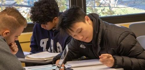 Three financial management students working at a table